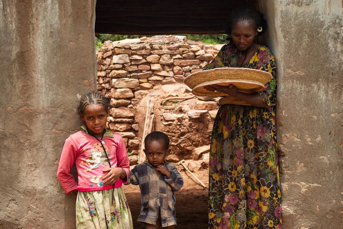 Familie aus der Region Tigray in Wukro Äthiopien Mutter mit ihren zwei Kindern mit Getreidekorb in der Hand