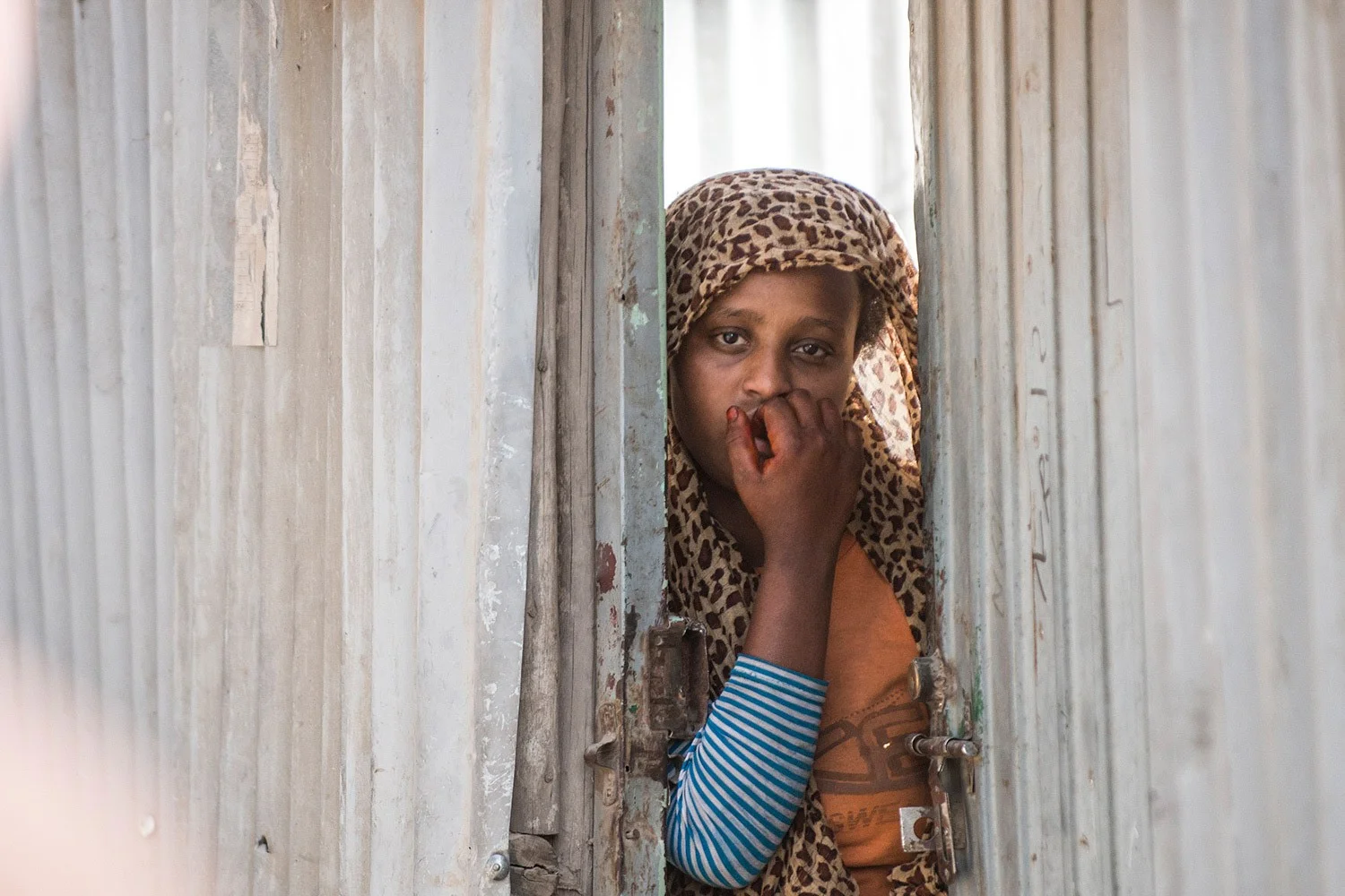 Arme Frau in Addis Abeba, Äthiopien | Stiftung Menschen für Menschen Arme Frau guckt aus einem Verschlag