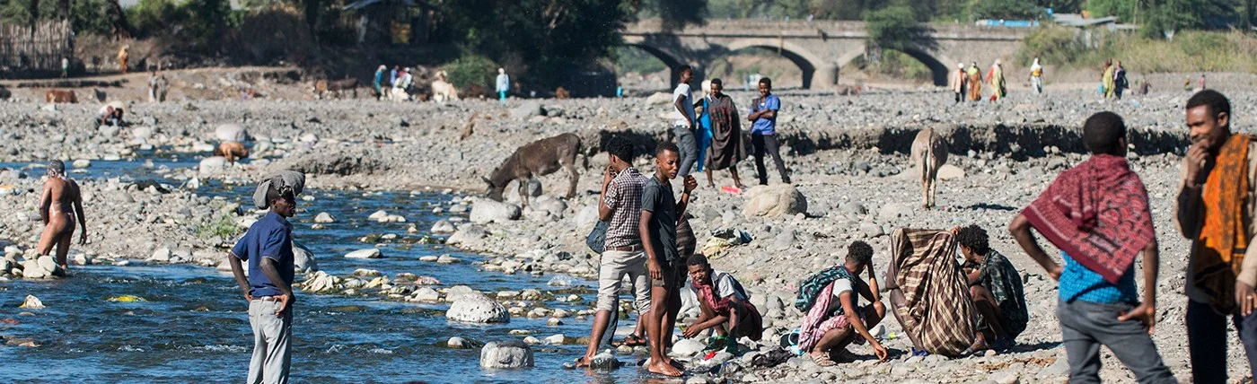Fluss in Shewarobit Äthiopien | Stiftung Menschen für Menschen Menschen baden und waschen sich am Fluss
