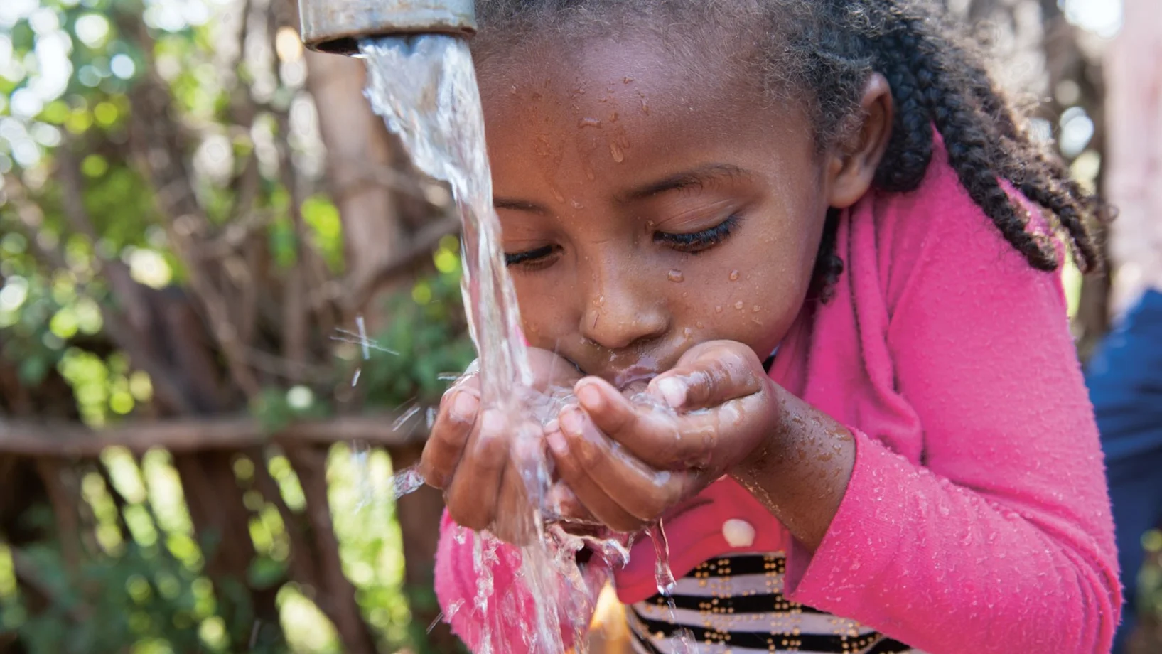 Mädchen trinkt Wasser | Stiftung Menschen für Menschen Mädchen trinkt Wasser von einem Hahn